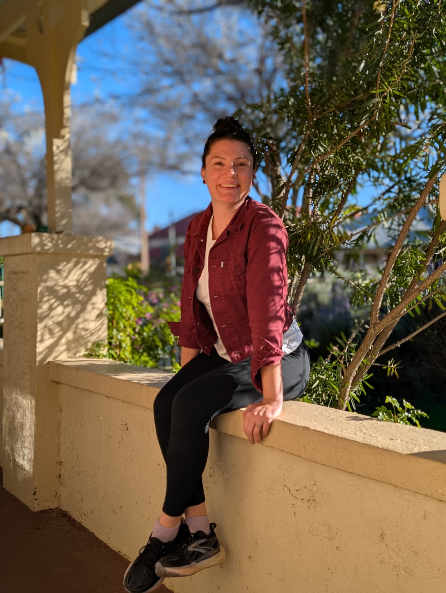 Jacqui, co-founder of Unleased, sitting on a verandah wall