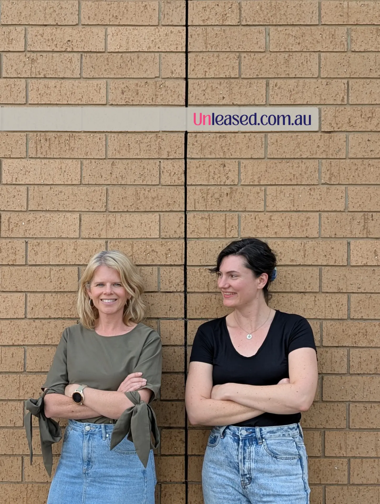 Unleased co-founders Clair Crowley and Jacqui Storey standing against a brick wall beneath an Unleased.com.au sign